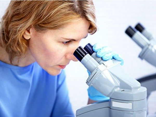 Женщина смотрит в микроскоп